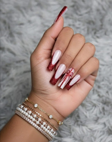 Red glitter nails with seasonal candy-cane accent design by Five Star Nails